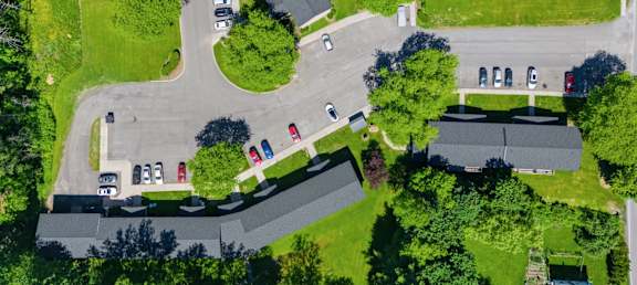 A parking lot with cars and a building in the background.