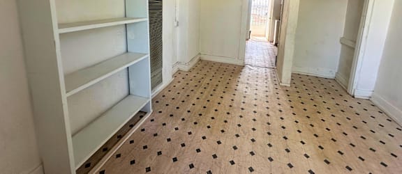 A room with a polka dot floor and a white shelf.