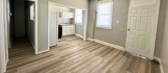 A room with a ceiling fan and wooden flooring.