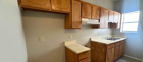 A kitchen with wooden cabinets and a sink.