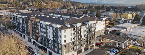 A large apartment complex with a parking lot in front.