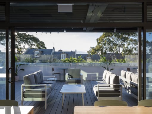 a patio with chairs and tables and a view of a house