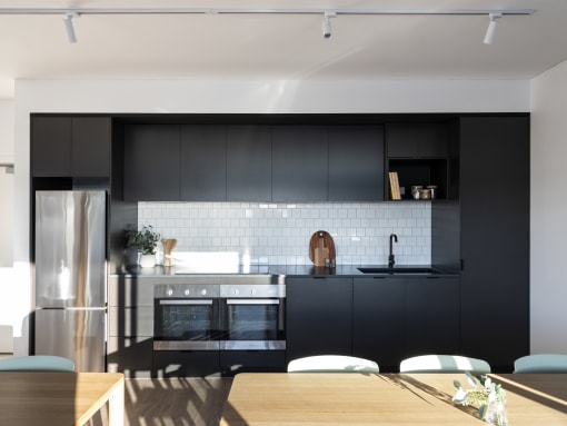 a kitchen with black cabinets and a wooden table