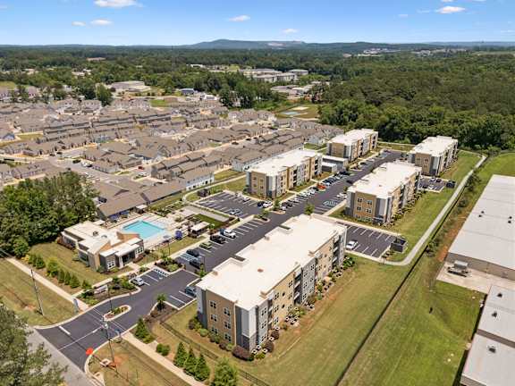 A bird's eye view of a suburban area with roads, buildings, and greenery.