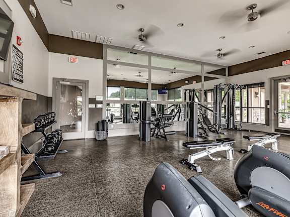 A gym with treadmills, weights and exercise equipment.