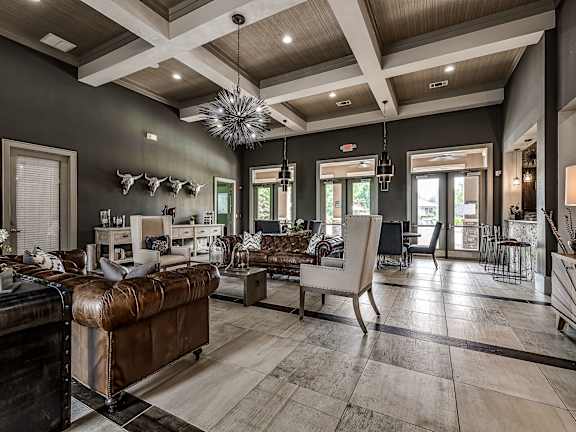 A living room with a brown leather couch and a wooden floor.