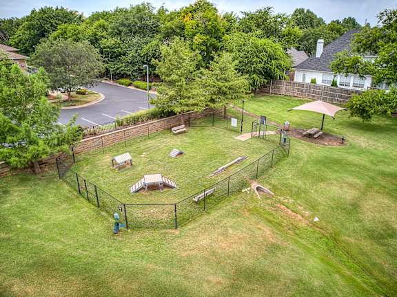 A park with a playground and a house in the background.