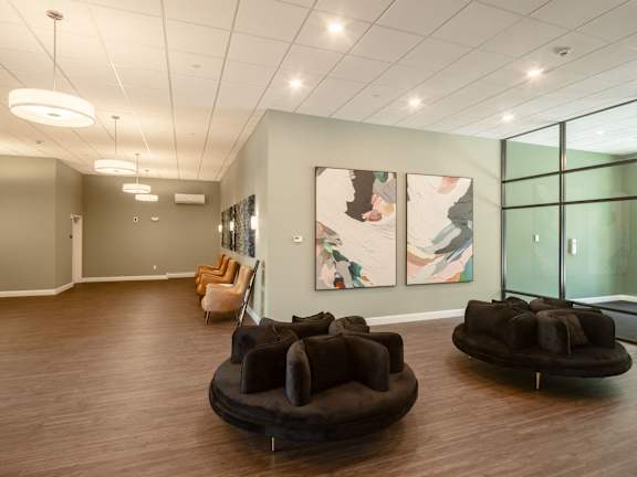 a large room with couches and paintings on the wall