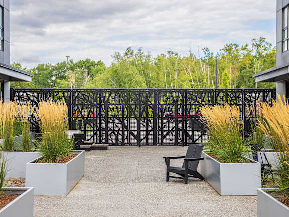 A black metal fence separates a garden area from a building.