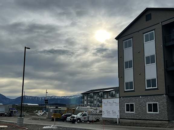the sun shining through the clouds over an apartment building