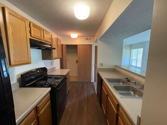 A kitchen with wooden cabinets and a black stove top oven.