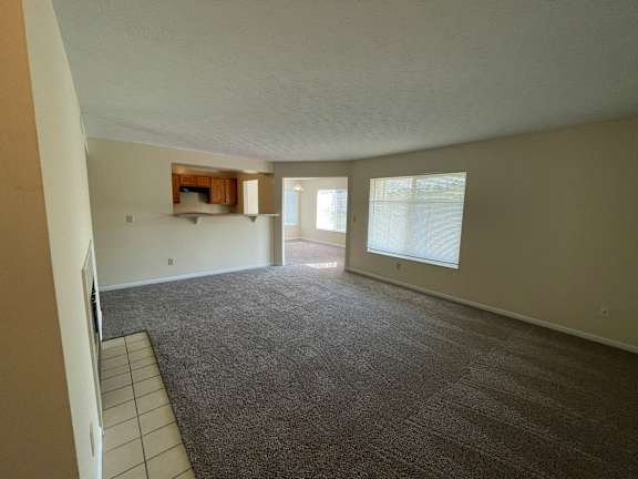 A room with a carpeted floor and a fireplace.