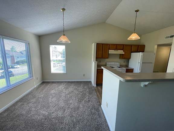 A kitchen area with a white counter and a window.