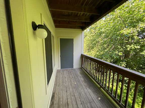 A balcony with a door and a lamp.