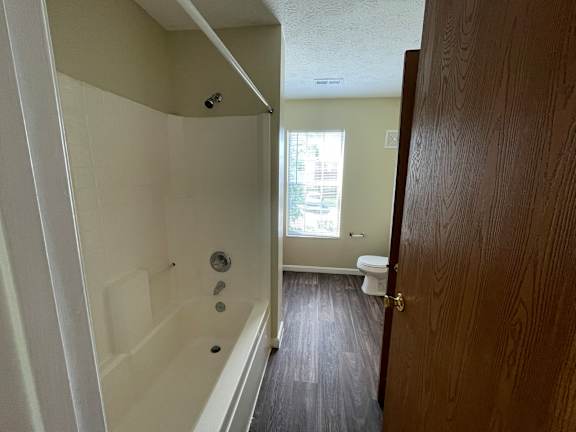 A white bathtub with a shower head and faucet in a bathroom.