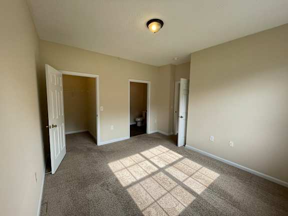 A room with carpeted floor and a ceiling light.
