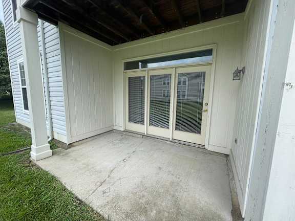 A white house with a sliding glass door and a concrete floor.at Twin Fountains, Ohio, 45040
