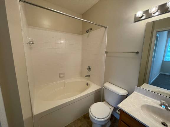 A white bathroom with a toilet, sink, and bathtub. at The Legends at Steeplechase Apartments, Richwood, Kentucky