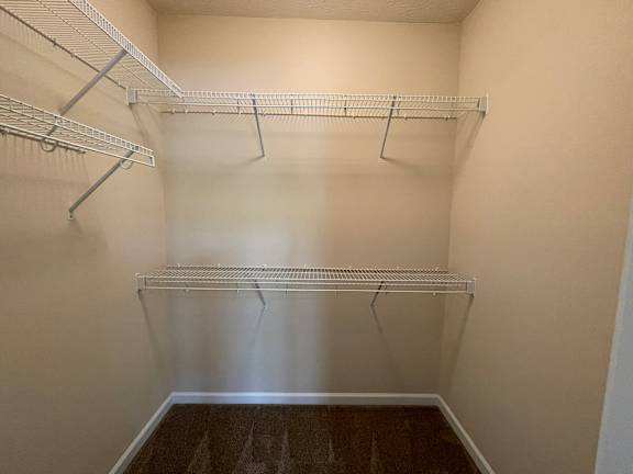 Empty walk-in closet with shelves and hangers. at The Legends at Steeplechase Apartments, Richwood, Kentucky