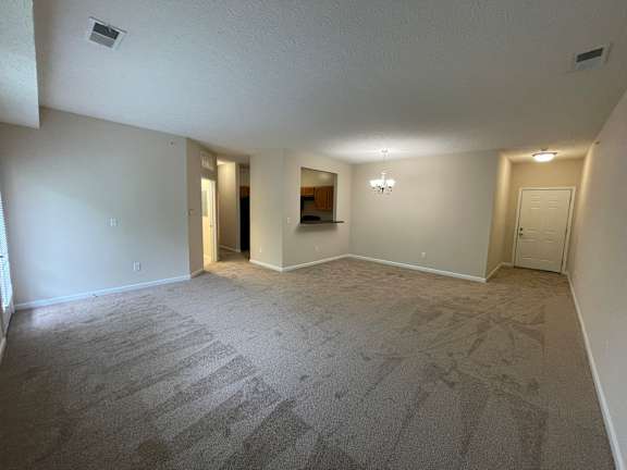 A spacious room with carpeted floor and white walls. at The Legends at Steeplechase, Richwood, Kentucky
