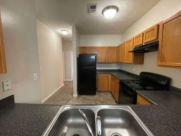 A kitchen with a black refrigerator and stove. at The Legends at Steeplechase, Richwood, 41094