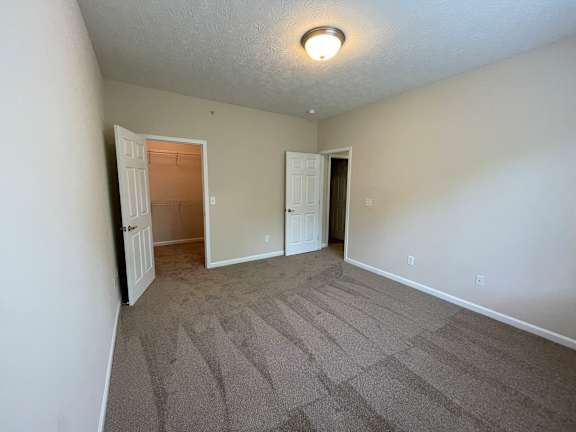 A room with carpeted floor and two doors. at The Legends at Steeplechase, Richwood, KY