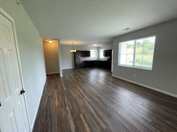 A room with wooden flooring and a white door.