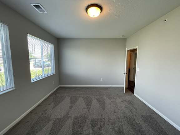 A room with a carpeted floor and a door.