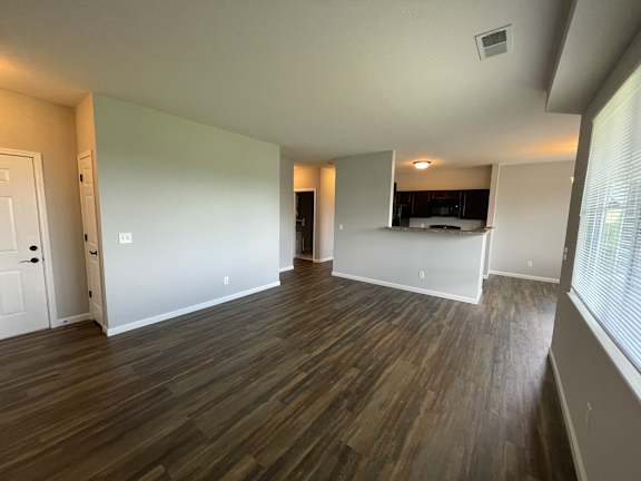 A room with wooden flooring and white walls.