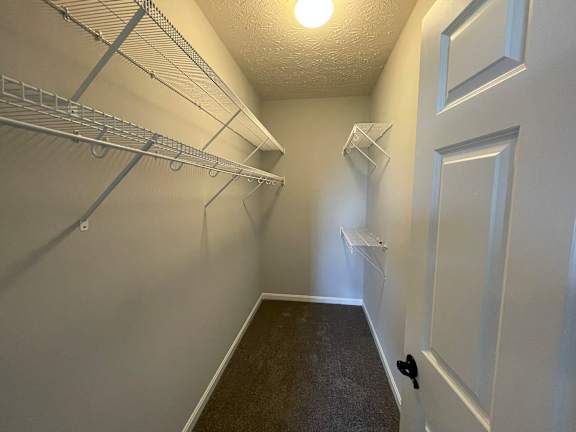 A hallway with a white door and a light on the ceiling.
