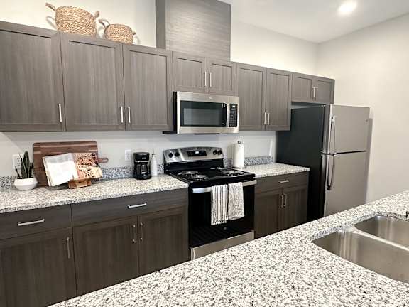 A kitchen with a black stove top oven and a black refrigerator.