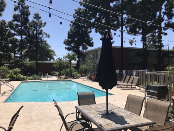 a swimming pool with a table and chairs around it