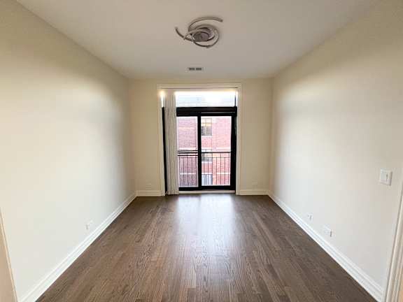 A room with wooden floors and a ceiling fan.