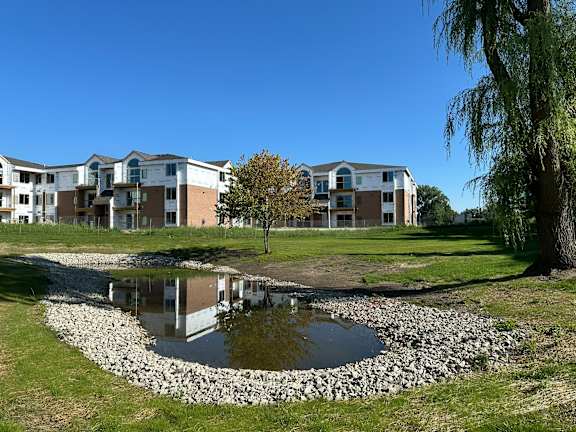 A pond in front of apartment buildings.