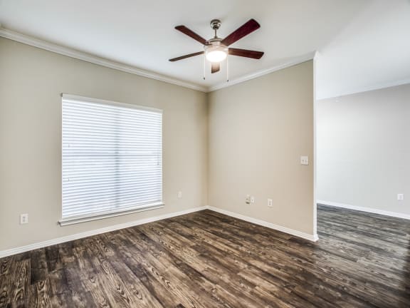 a bedroom with hardwood floors and a ceiling fan at The Canyons Apartments, Fort Worth, TX