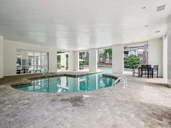 A large indoor swimming pool with a tiled floor.