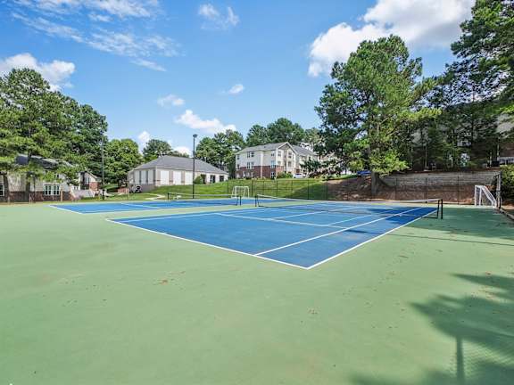 A tennis court with a blue surface and white boundary lines.