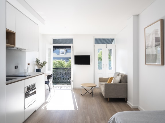 a kitchen and living room with a door to a balcony