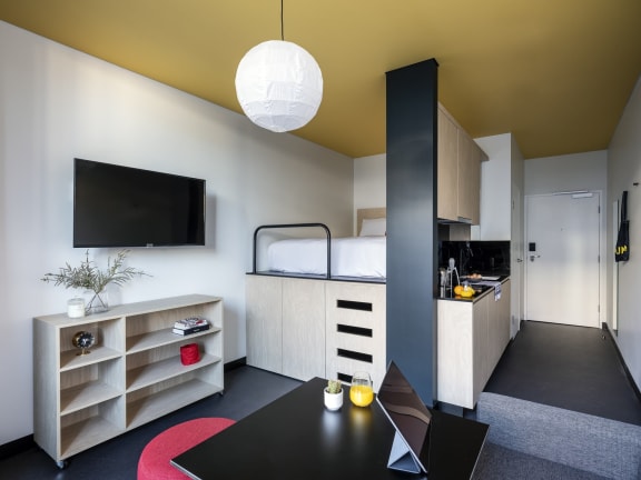 a small room with a bed and a table and a tv