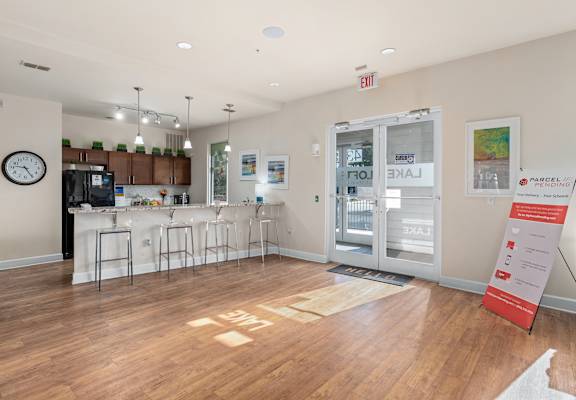 A white room with a bar and a clock on the wall at Lake Lofts at Deerwood, Jacksonville, FL, 32216