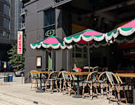 A restaurant with tables and chairs under striped umbrellas.