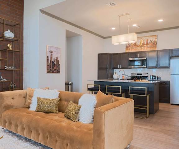 A living room with a couch in front of a kitchen at 35 Degrees.