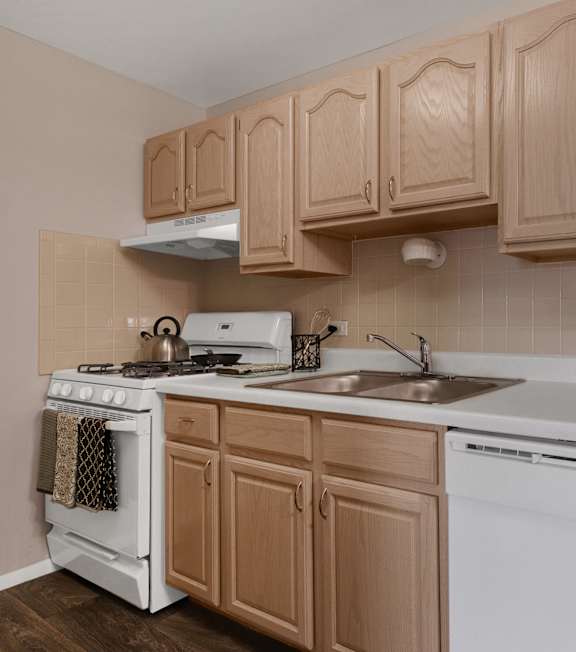 a kitchen with white appliances and wooden cabinets at St Charles Square Apartments, Carol Stream, IL, 60188