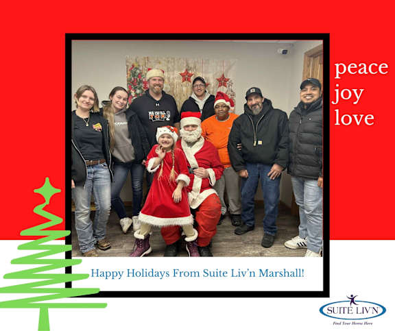 A group of people are posing for a photo with Santa Claus.
