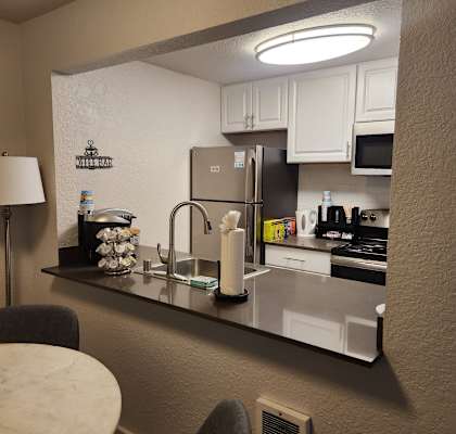 A kitchen with a refrigerator, microwave, and sink.