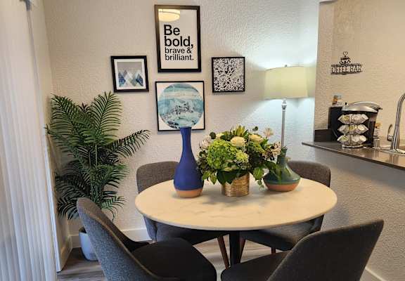 A dining room with a round table and chairs.