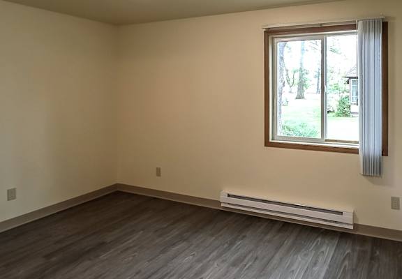 A room with a window and a wall-mounted light fixture.
