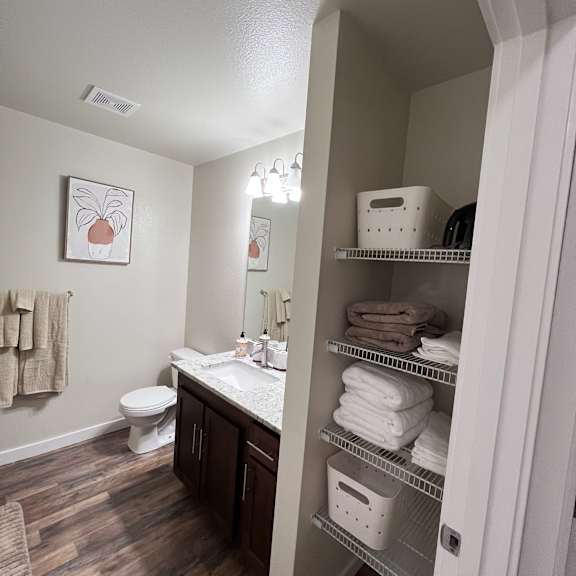 A bathroom with a toilet, sink, and towels.