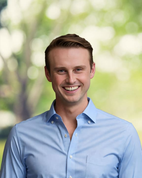 a portrait of a young man wearing a blue shirt