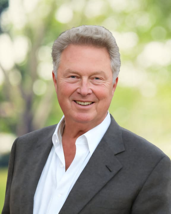 a man in a suit and tie smiling